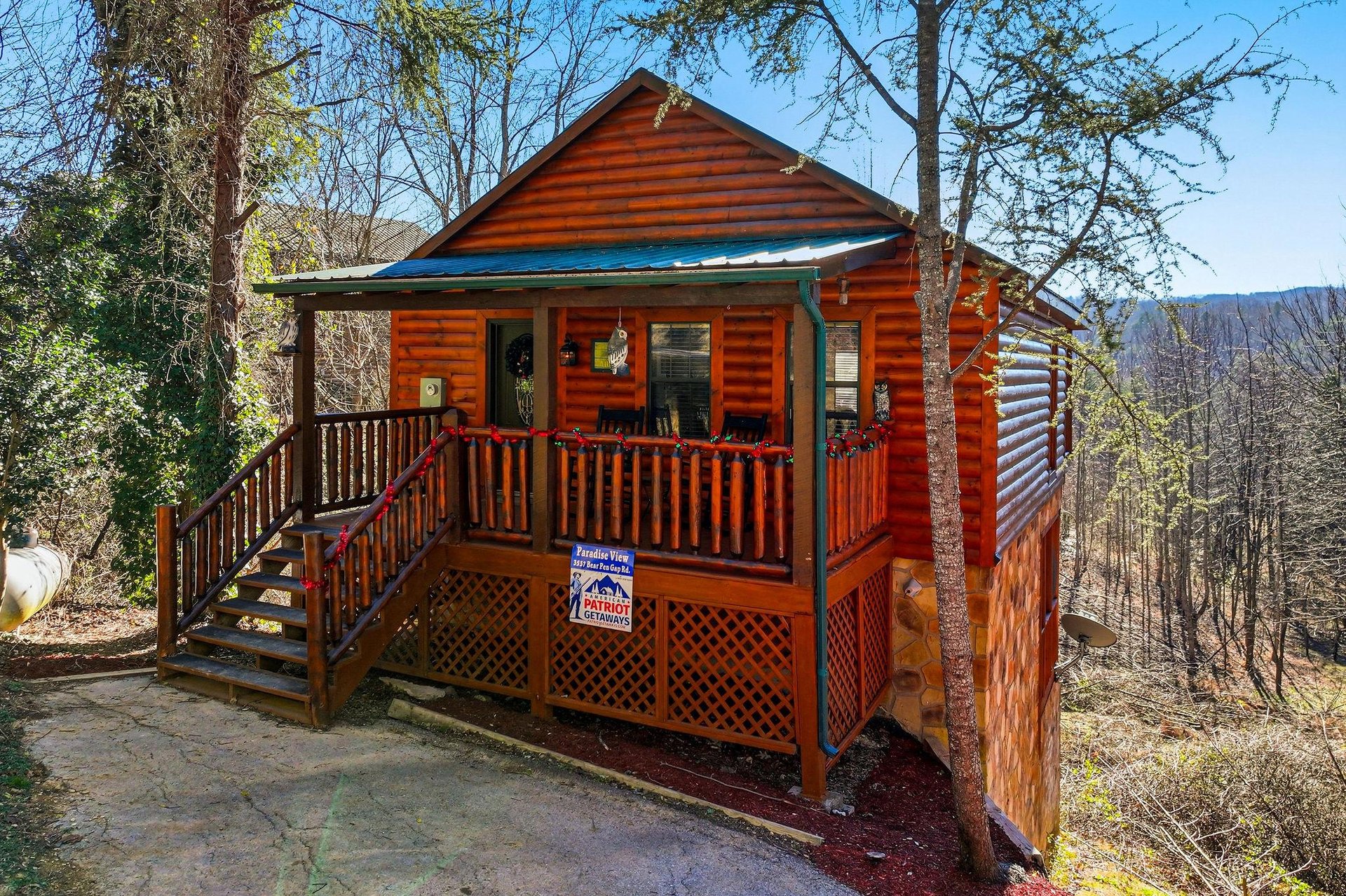 Rustic log cabin with wraparound porch nestled among trees, offering mountain views and woodland privacy for a peaceful getaway.