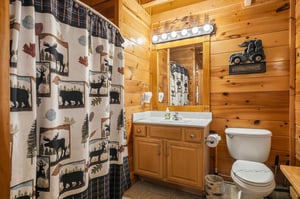 Warm wood paneling and rustic charm welcome you to this cozy cabin bathroom, complete with playful wildlife touches and everything you need to feel at home.