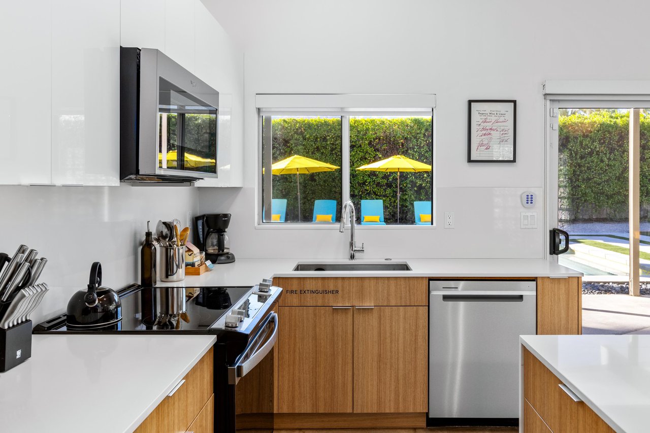 Cook your favorite meals in this sleek modern kitchen while enjoying poolside views through expansive windows.