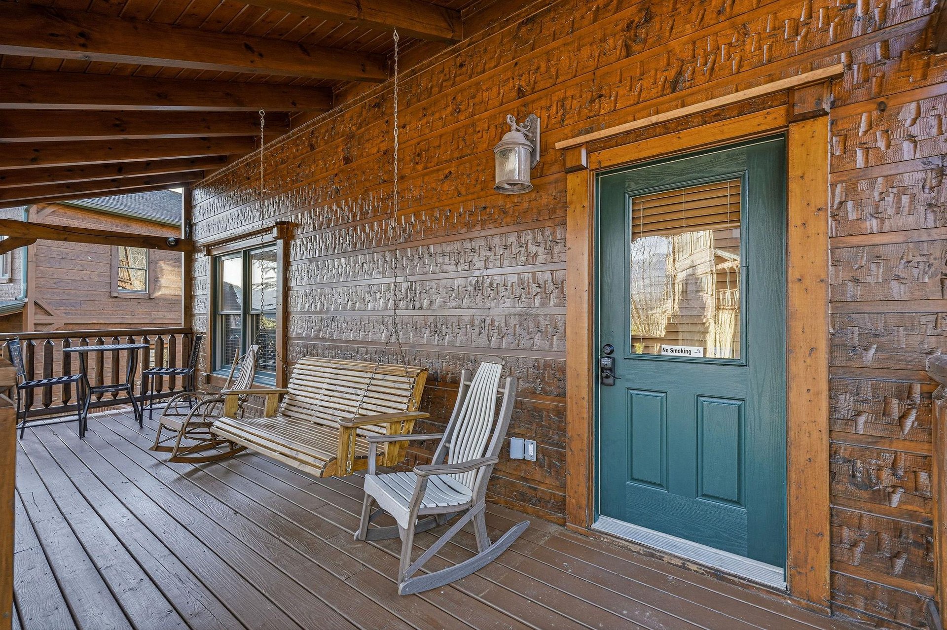 Charming covered porch with rustic wooden seating invites you to relax and soak in serene mountain views before stepping inside your cozy retreat.