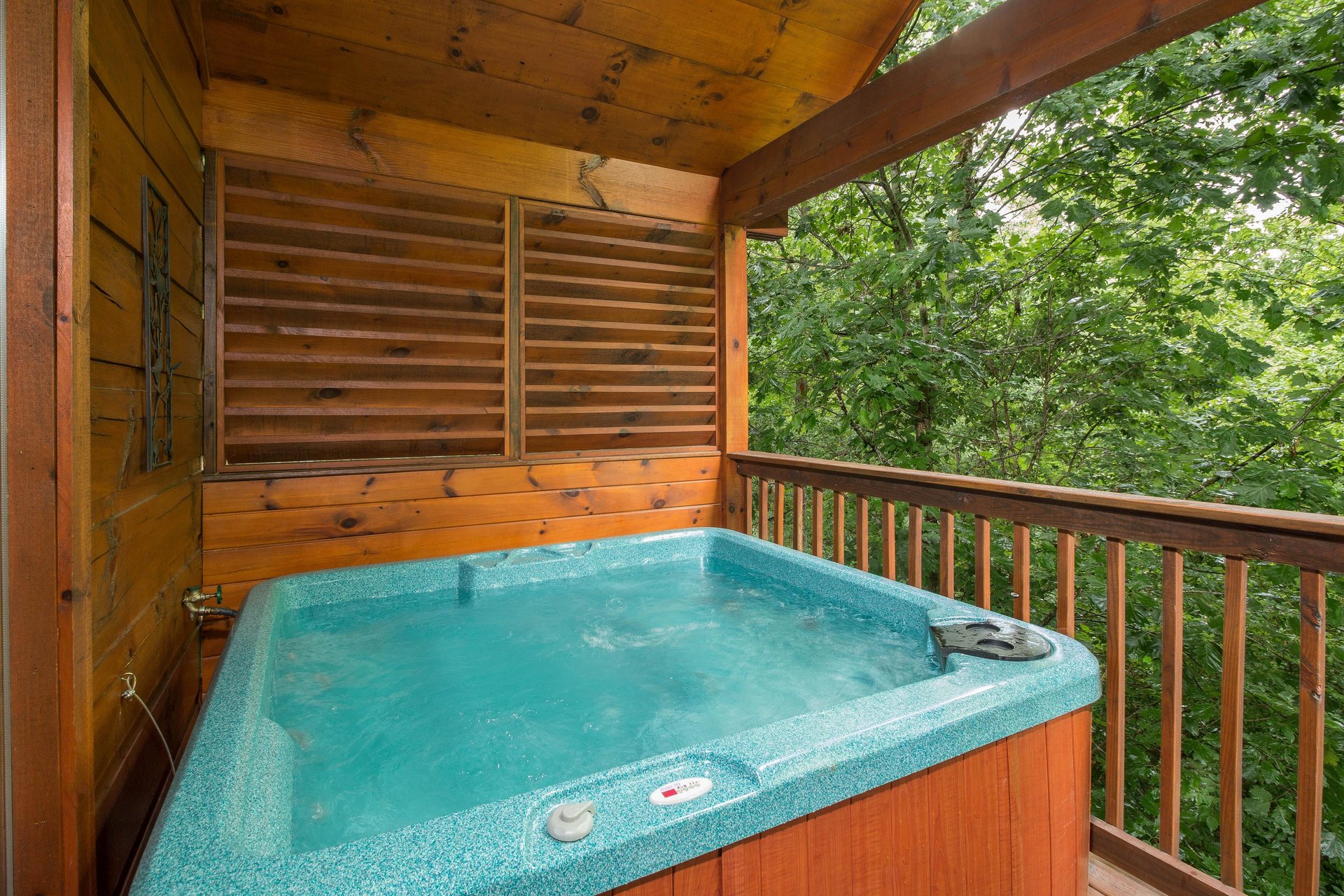 Hot tub on a covered deck at Kellys Cabin, a 1 bedroom cabin rental located in Pigeon Forge