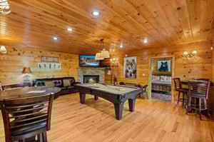 Pool table with stone fireplace and table and chairs