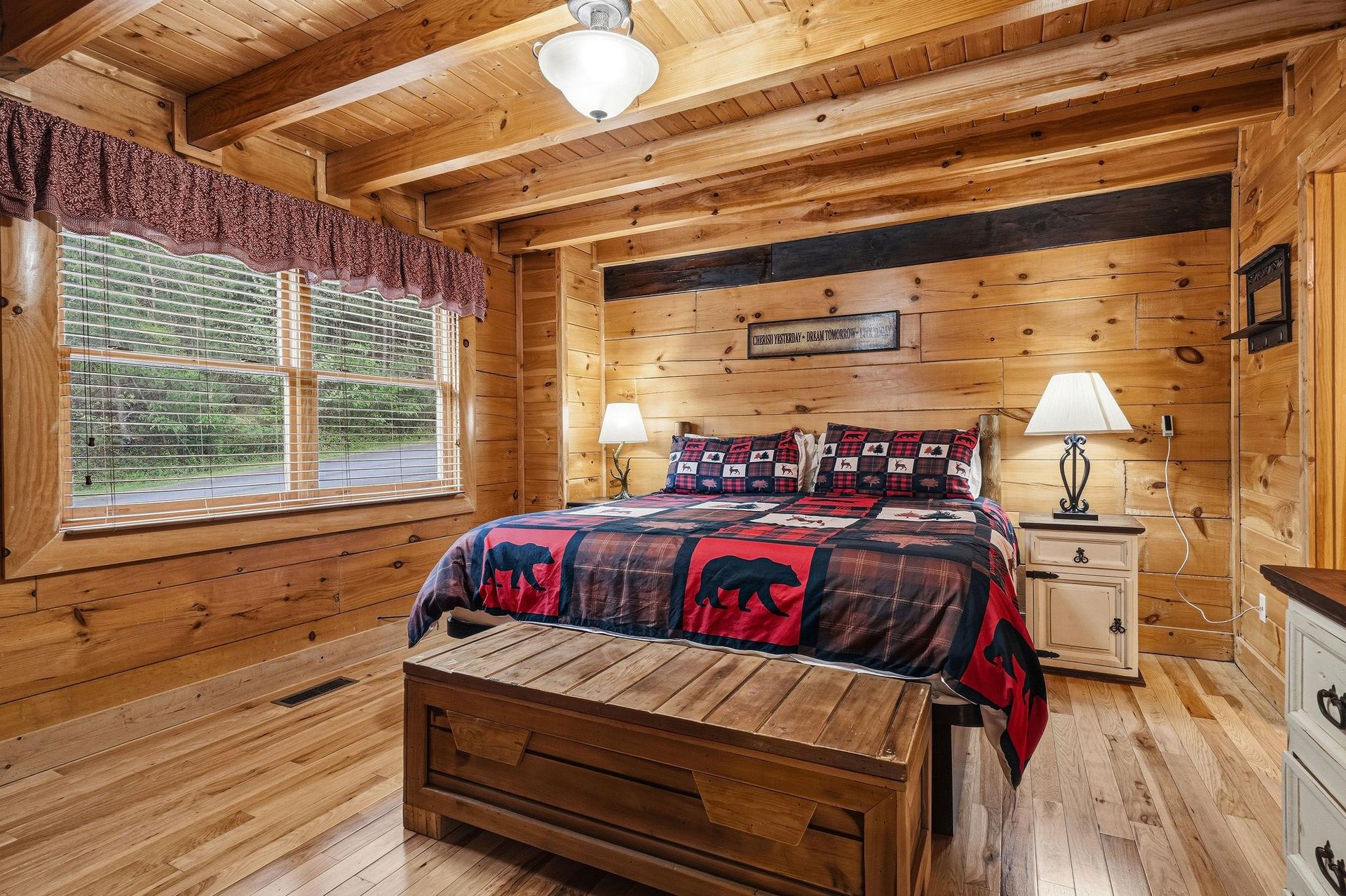 Snuggle into your cozy log cabin bedroom, where rustic charm meets modern comfort beneath beautiful exposed beams.