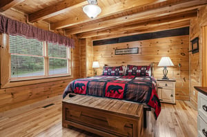 Snuggle into your cozy log cabin bedroom, where rustic charm meets modern comfort beneath beautiful exposed beams.