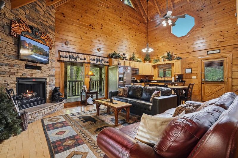 Sink into rich leather sofas by your crackling fireplace, where rustic cabin charm meets modern comfort in this inviting retreat.