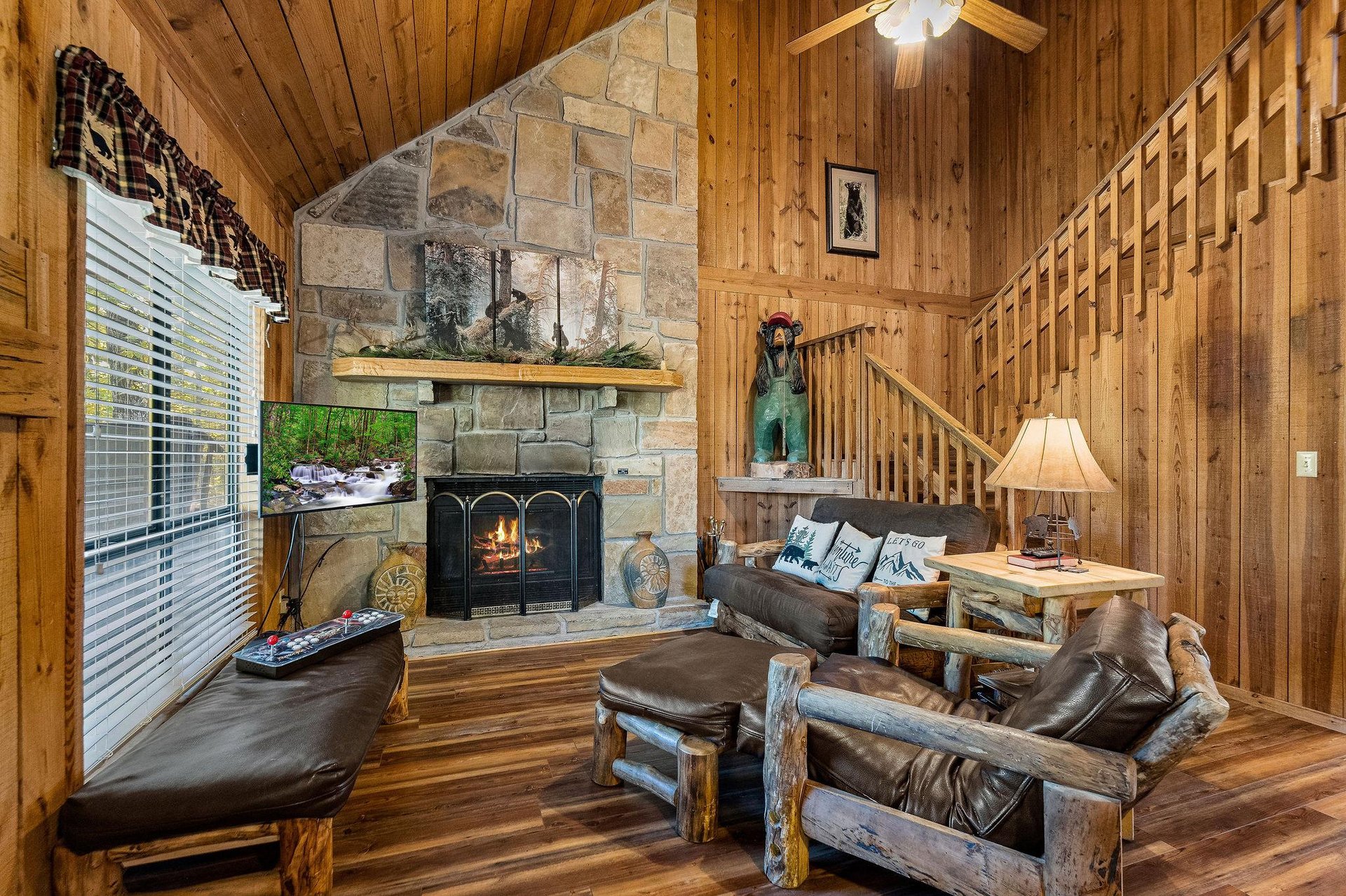 Living room with stone fireplace and bench under window