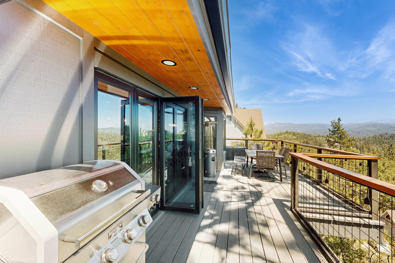 Top deck off the living room with panoramic views, BBQ, outdoor dining, and heater.