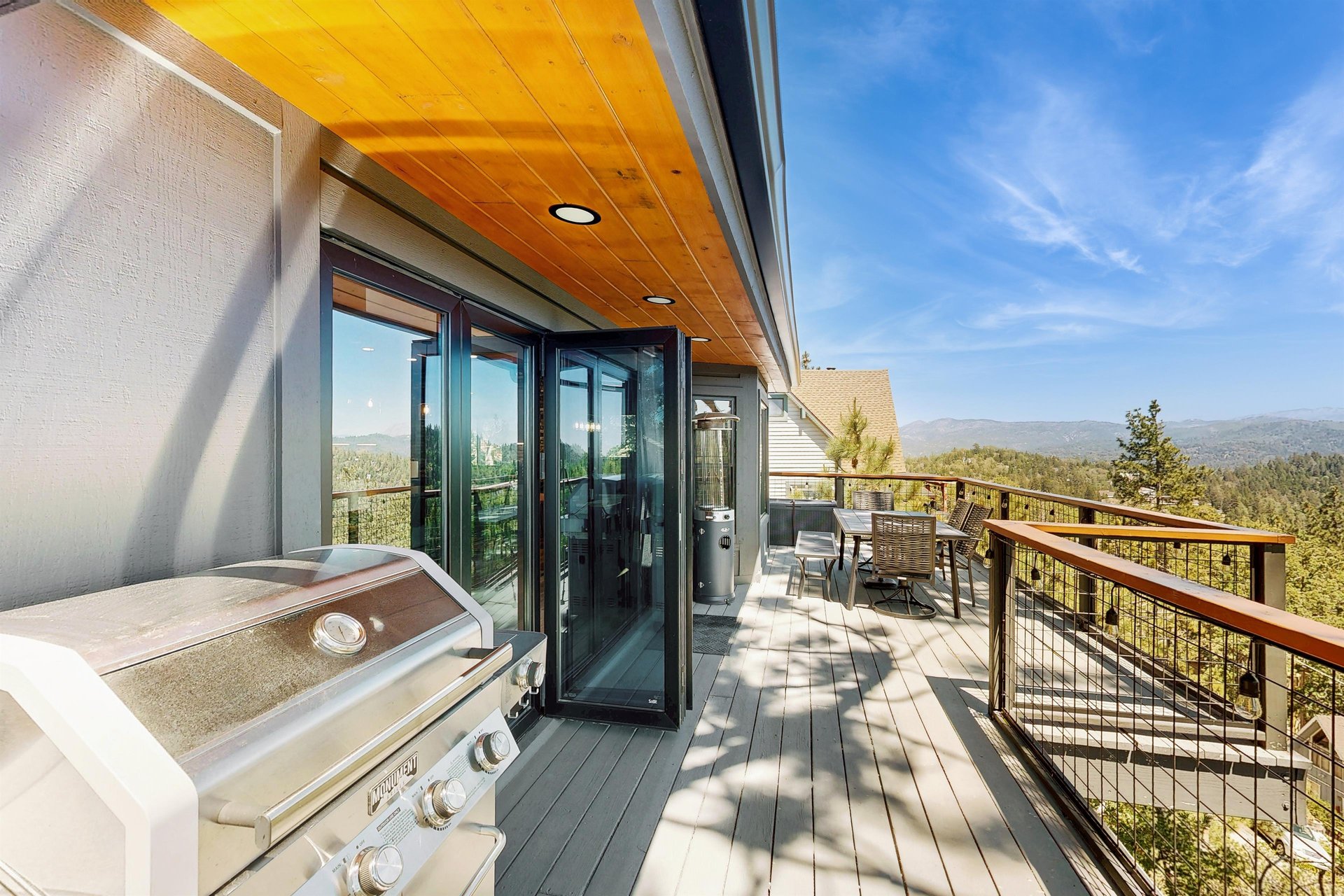 Top deck off the living room with panoramic views, BBQ, outdoor dining, and heater.