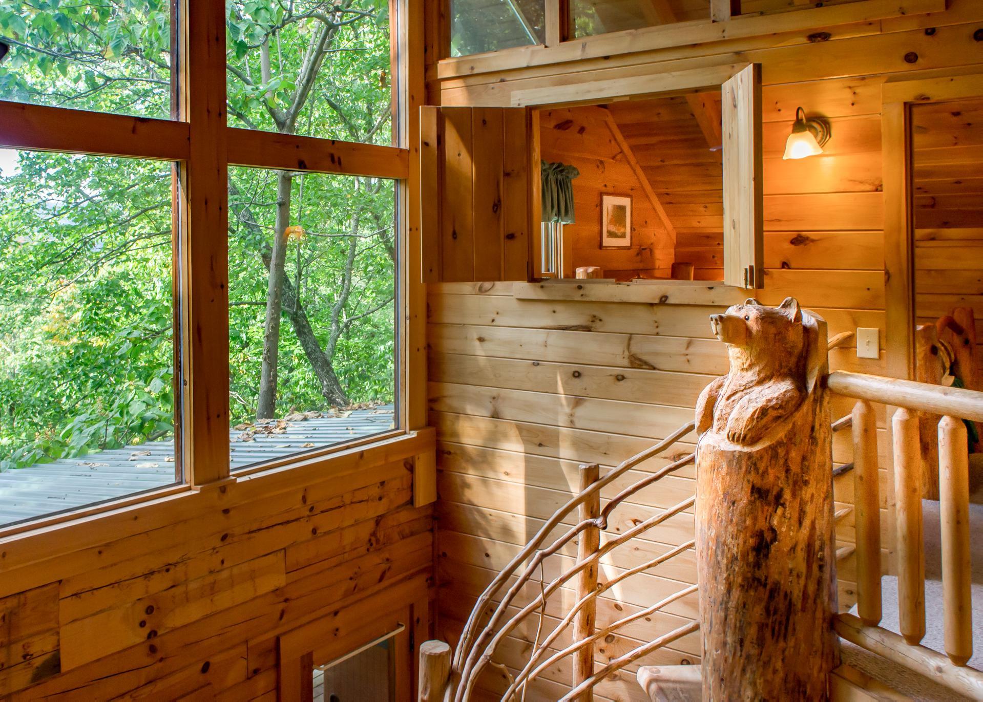 Take the spiral staircase to the second floor and youre greeted by a whimsical bear carving that overlooks the open living area.