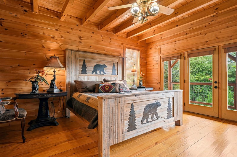 Retreat to your cozy cabinstyle bedroom with soaring wood ceilings and tranquil forest views just beyond the glass doors.