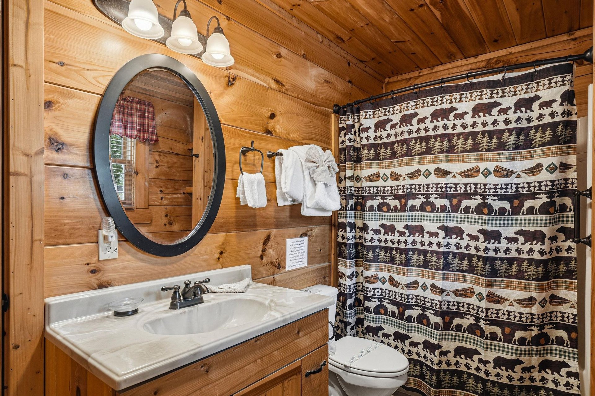Rustic charm meets comfort in this cozy cabin bathroom. Warm knotty pine walls create an inviting atmosphere, while plush towels and thoughtful touches ensure your stay feels like home.