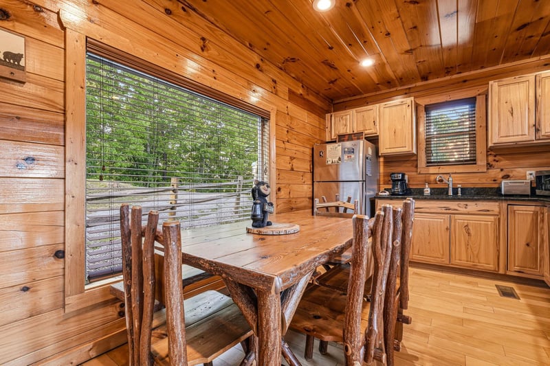 Gather around the handcrafted log table in your fully equipped kitchen, where warm wood tones and forest views create the perfect backdrop for your mountain getaway meals.