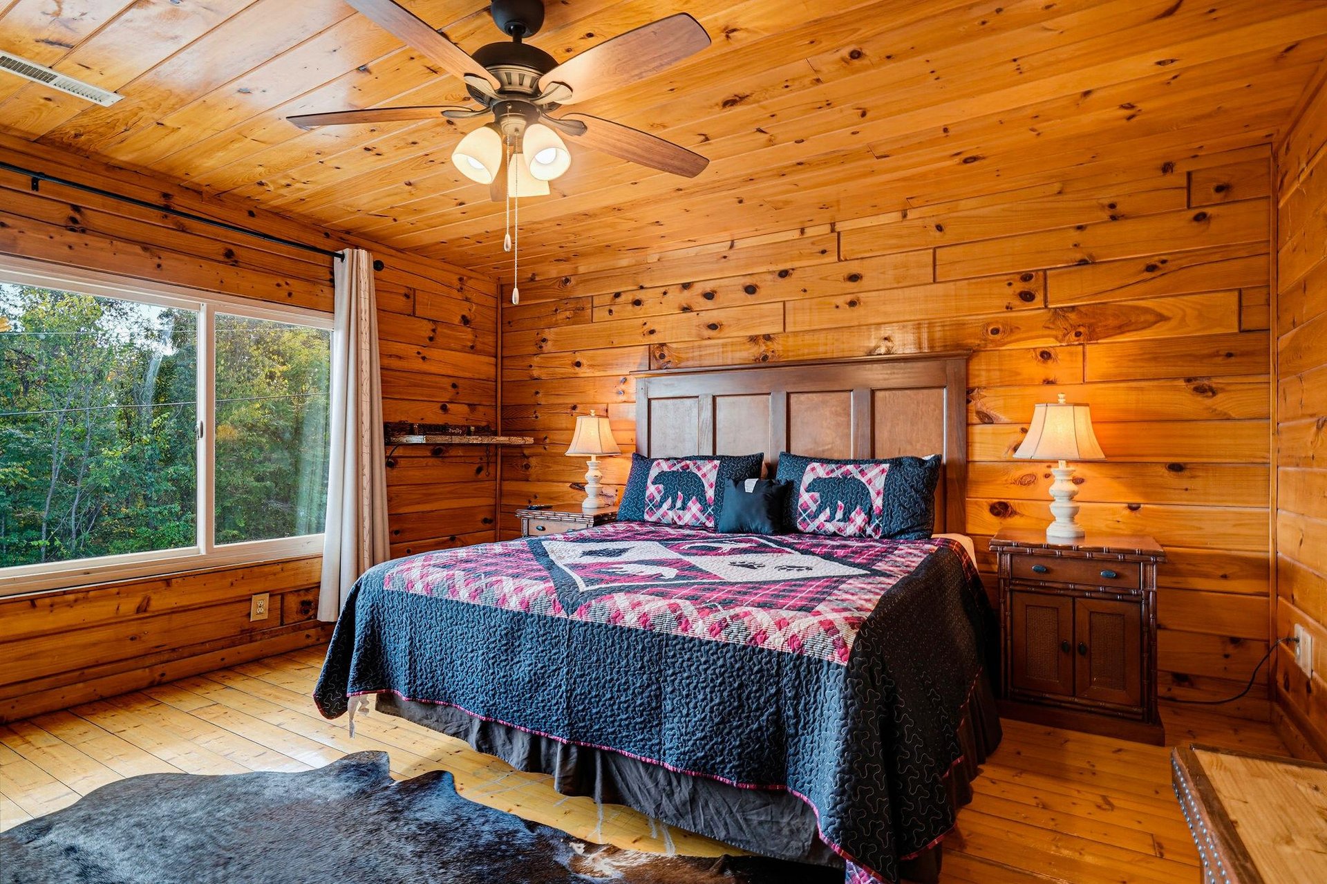 Drift off in your cozy cabinstyle bedroom, where natural wood surrounds you and a large window frames peaceful forest views. The rustic charm and thoughtful details make this your perfect mountain re