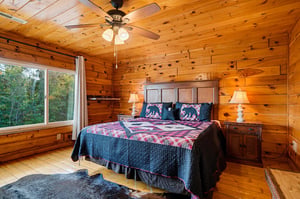 Drift off in your cozy cabinstyle bedroom, where natural wood surrounds you and a large window frames peaceful forest views. The rustic charm and thoughtful details make this your perfect mountain re