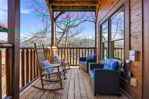 Unwind on your private deck with mountain views, cozy seating, and peaceful winter scenery stretching beyond.