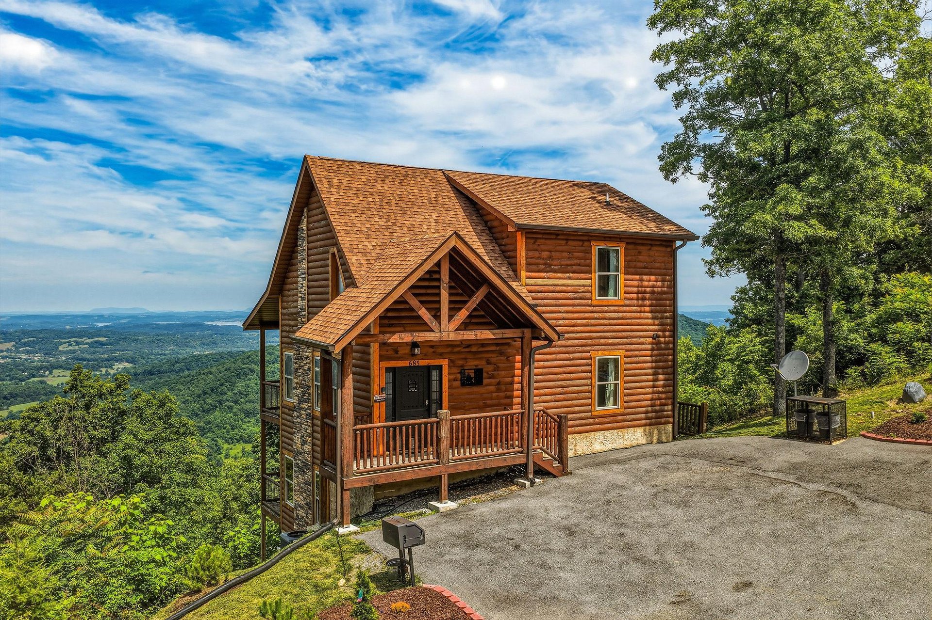 A secluded mountain cabin perched on a ridgeline, surrounded by lush forest with expansive valley views stretching to distant horizons—an idyllic retreat location.