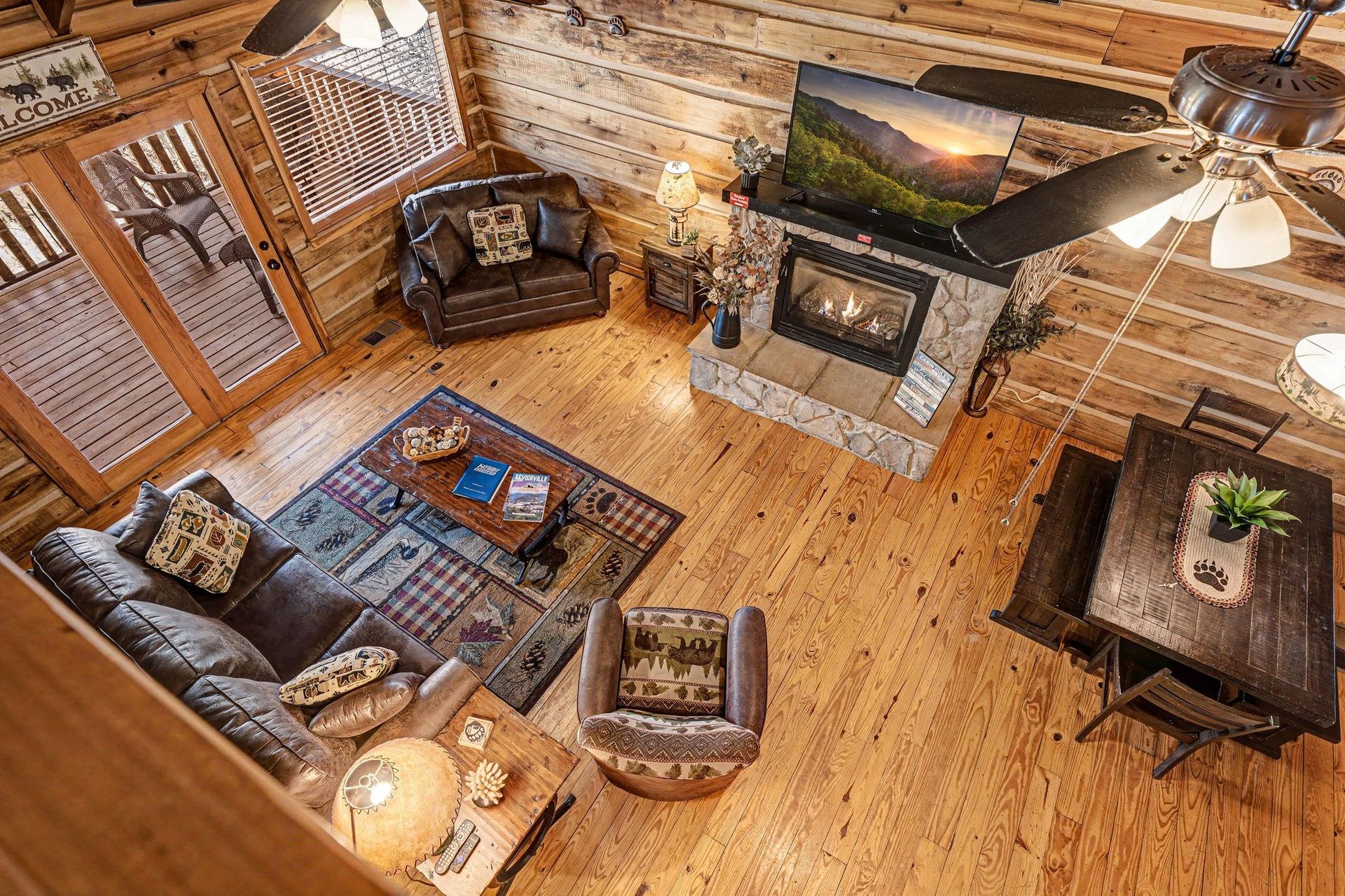 Relax in your cozy log cabin living room with leather seating, warm fireplace, and rustic charm perfect for mountain getaways.