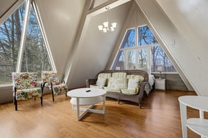 Relax in your bright Aframe retreat with soaring cathedral ceilings and panoramic forest views through dramatic triangular windows.