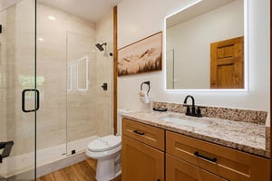 Step into your private bathroom featuring a luxurious walkin shower and warm wood accents that create a welcoming retreat after your mountain adventures.