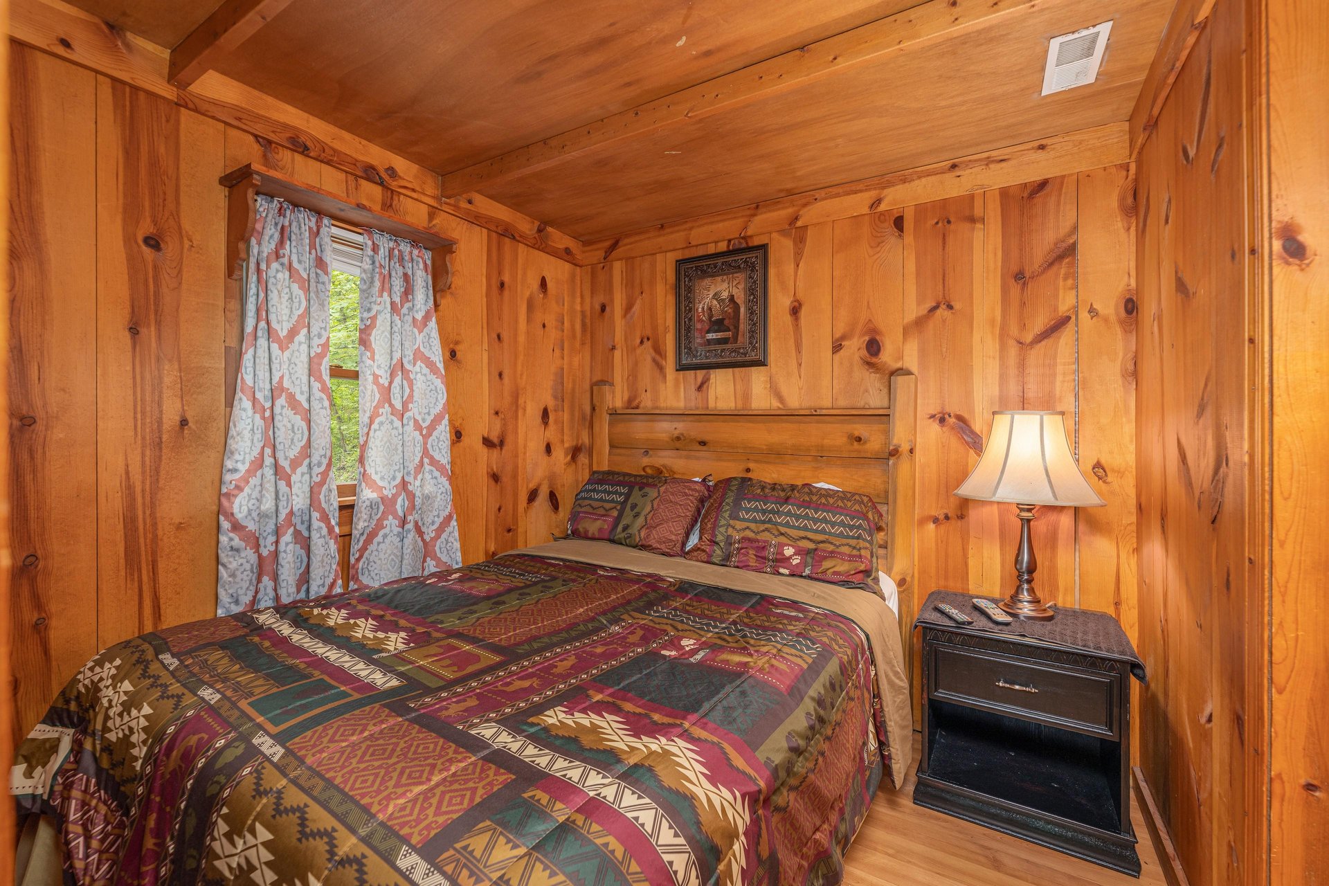 Bedroom with a night stand and a lamp at Heavenly Hideaway, a 2bedroom cabin rental located in Gatlinburg