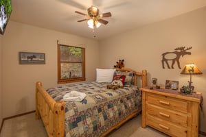 Bedroom with log bed and night stand at Lazy Bear Retreat, a 4 bedroom cabin rental located in Pigeon Forge