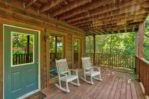 rocking chairs on a covered deck at angels majestic view a 3 bedroom cabin rental located in pigeon forge