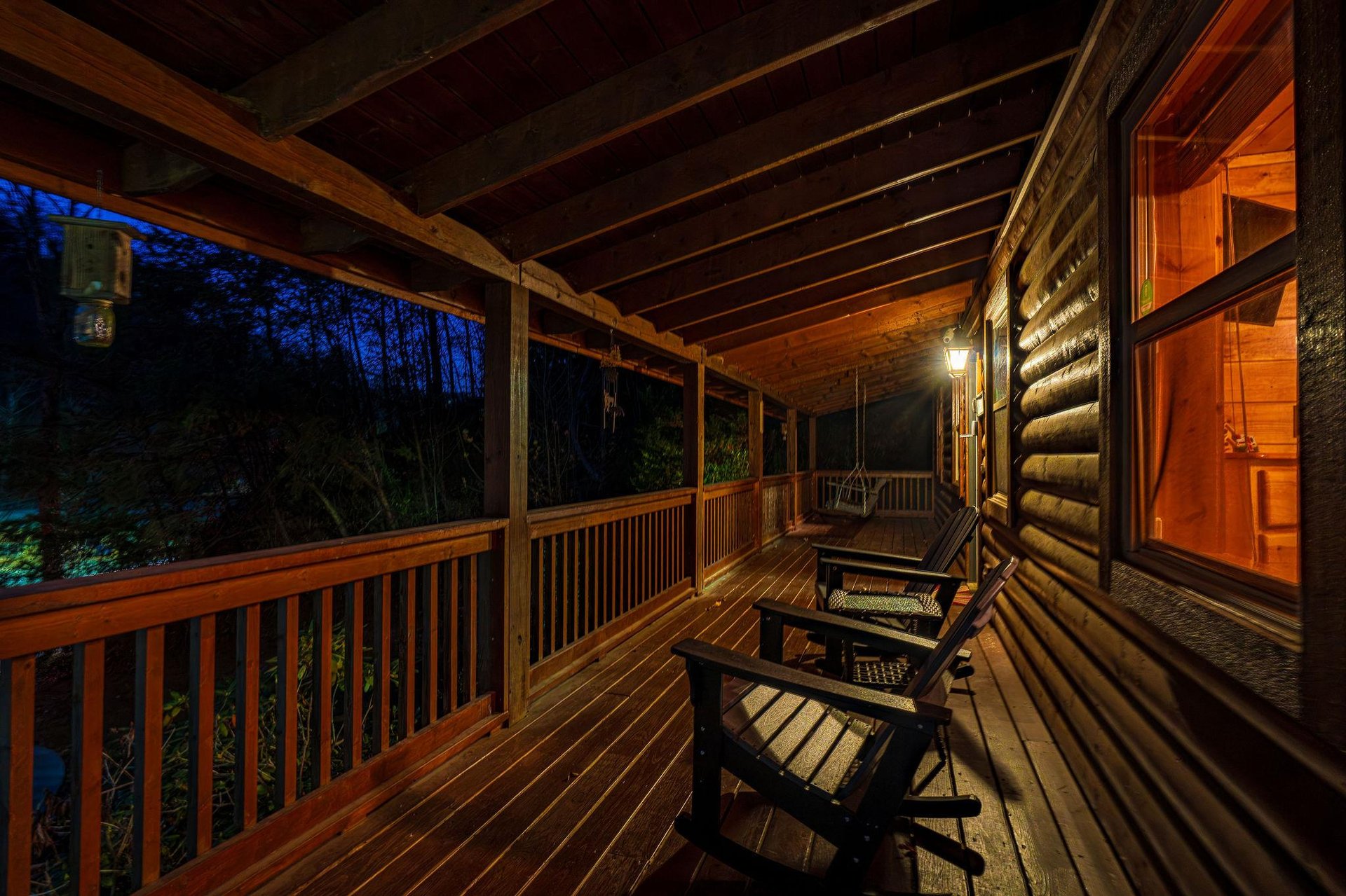 Evening brings a special magic to this peaceful covered porch. Sink into the rocking chairs, wrapped in warm light, and listen to the forest settle into night around you.