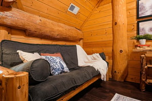 Wrap yourself in cozy warmth inside your rustic log cabin bedroom, where natural wood beams and handcrafted furnishings create an inviting mountain retreat perfect for unwinding after adventures.