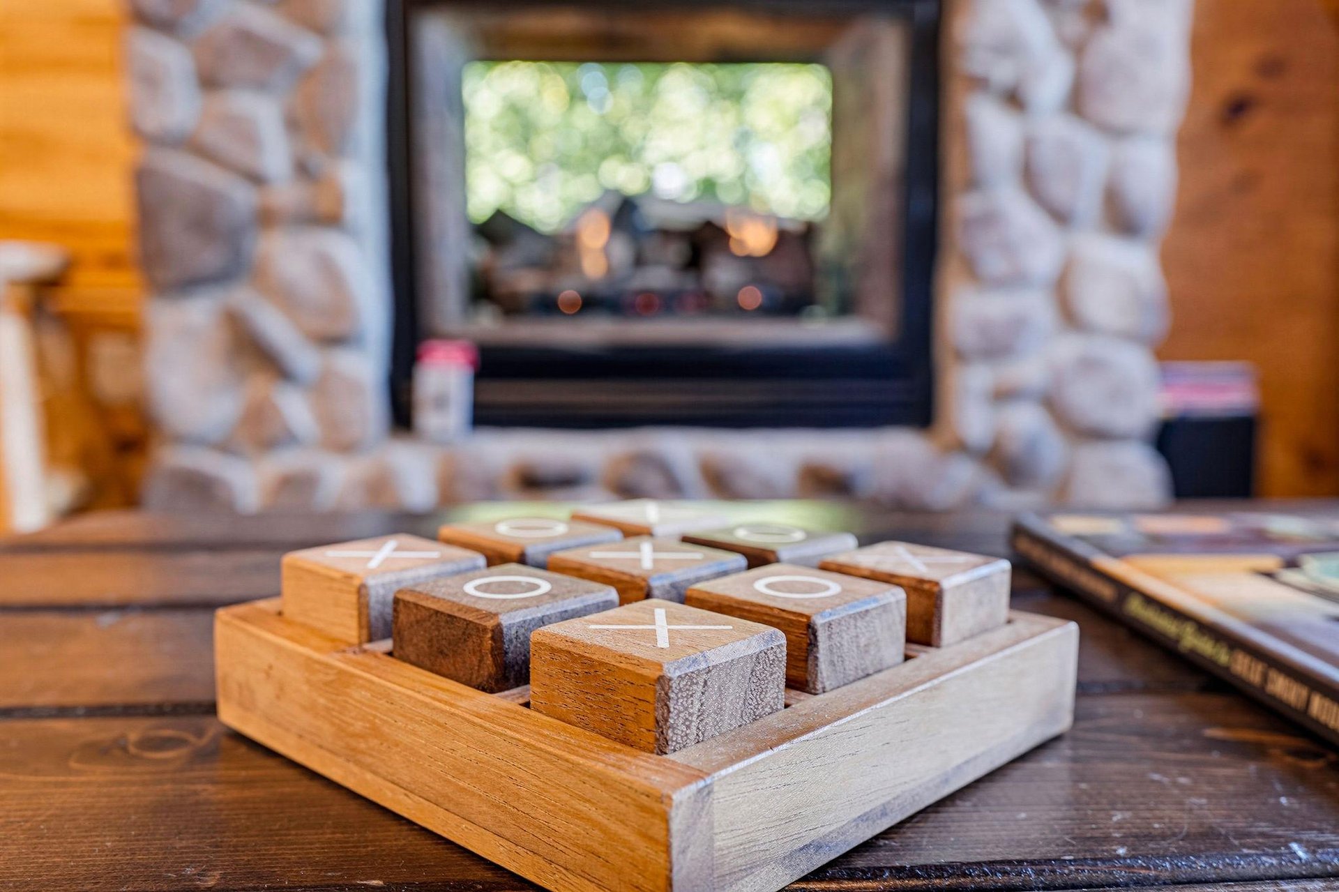 Warm up beside the stone fireplace with a friendly game of tictactoe—perfect for cozy evenings in.