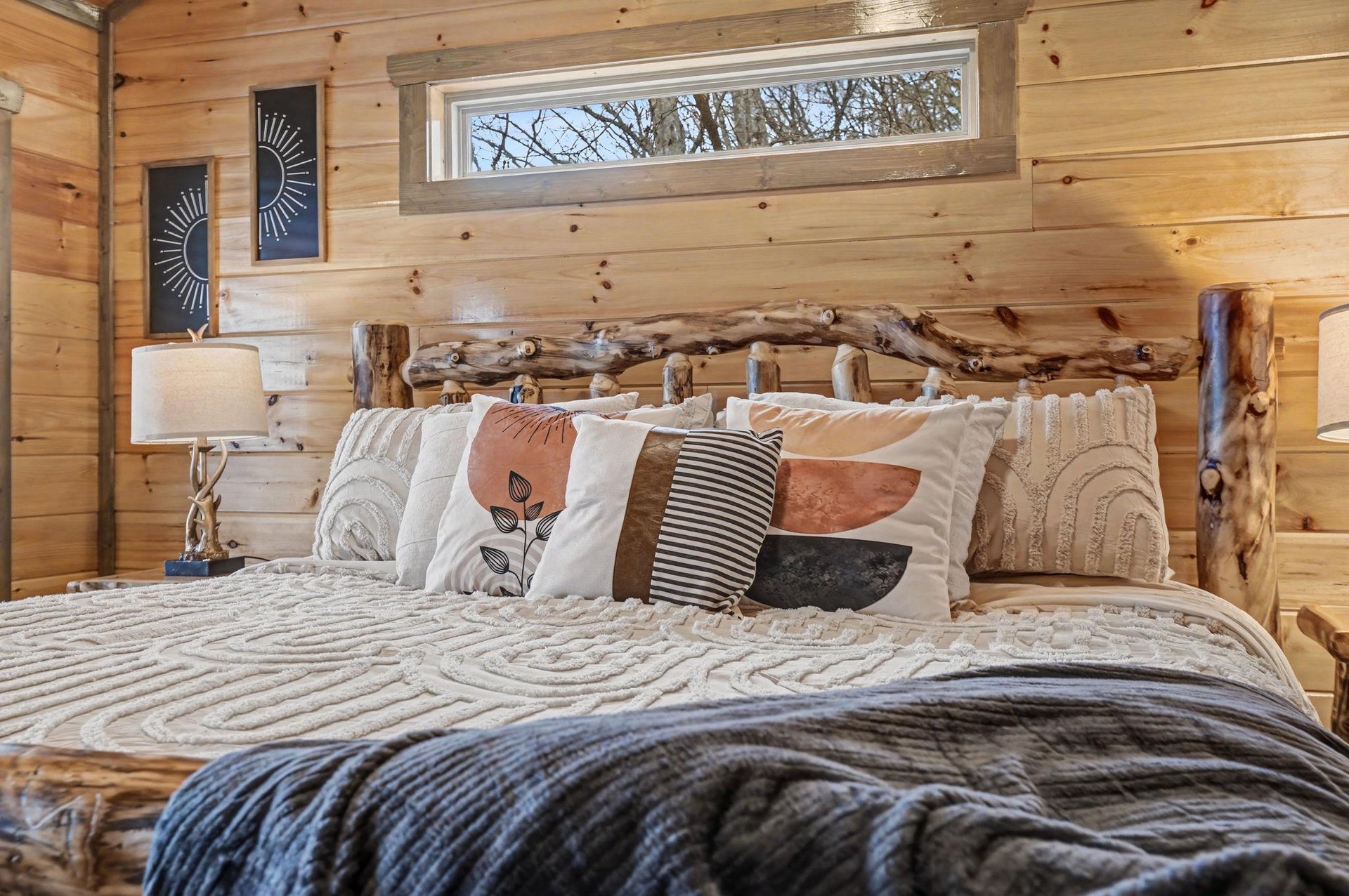 Drift off in this cozy log cabin bedroom, where rustic charm meets modern comfort with soft linens and natural wood surroundings.