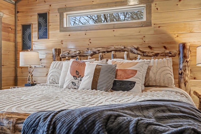 Drift off in this cozy log cabin bedroom, where rustic charm meets modern comfort with soft linens and natural wood surroundings.