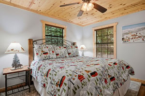 Your cozy bedroom features charming cabin touches, from the warm wood ceiling to playful outdoorthemed bedding. Natural light filters through bamboo blinds, creating a peaceful retreat for your mount