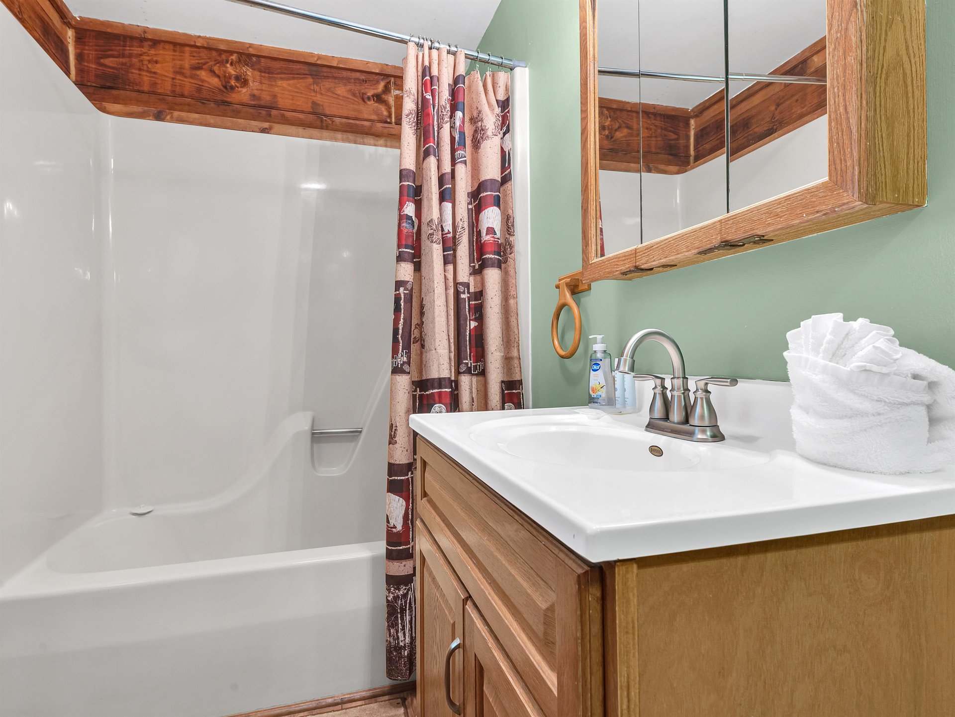 Refresh in your private bathroom featuring rustic wood accents, a soaking tub, and fluffy towels waiting for your arrival.