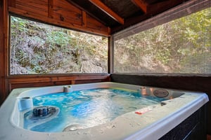 Slip into your private hot tub and let the warm water melt away stress while you gaze out at lush natural surroundings framed by rustic wood and screens.