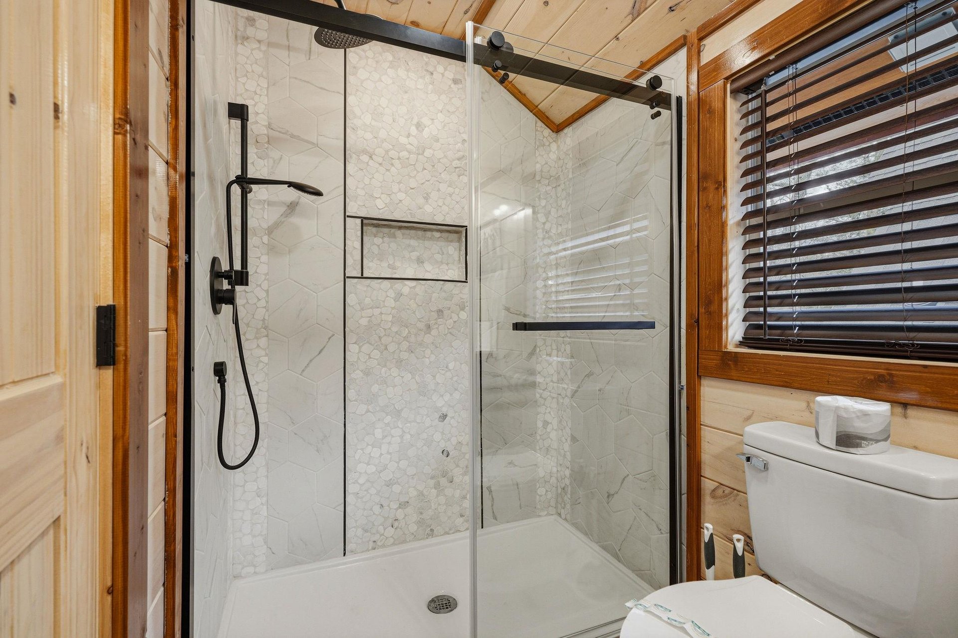 Step into your luxurious bathroom featuring marbletiled shower with modern fixtures and rustic wood accents creating perfect mountain retreat atmosphere.
