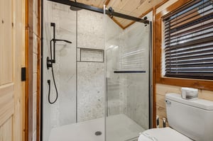 Step into your luxurious bathroom featuring marbletiled shower with modern fixtures and rustic wood accents creating perfect mountain retreat atmosphere.