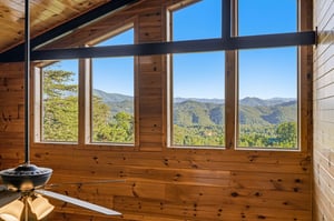 Dramatic floortoceiling windows frame stunning mountain vistas, filling this rustic retreat with natural light and bringing the beauty of the landscape right to you.