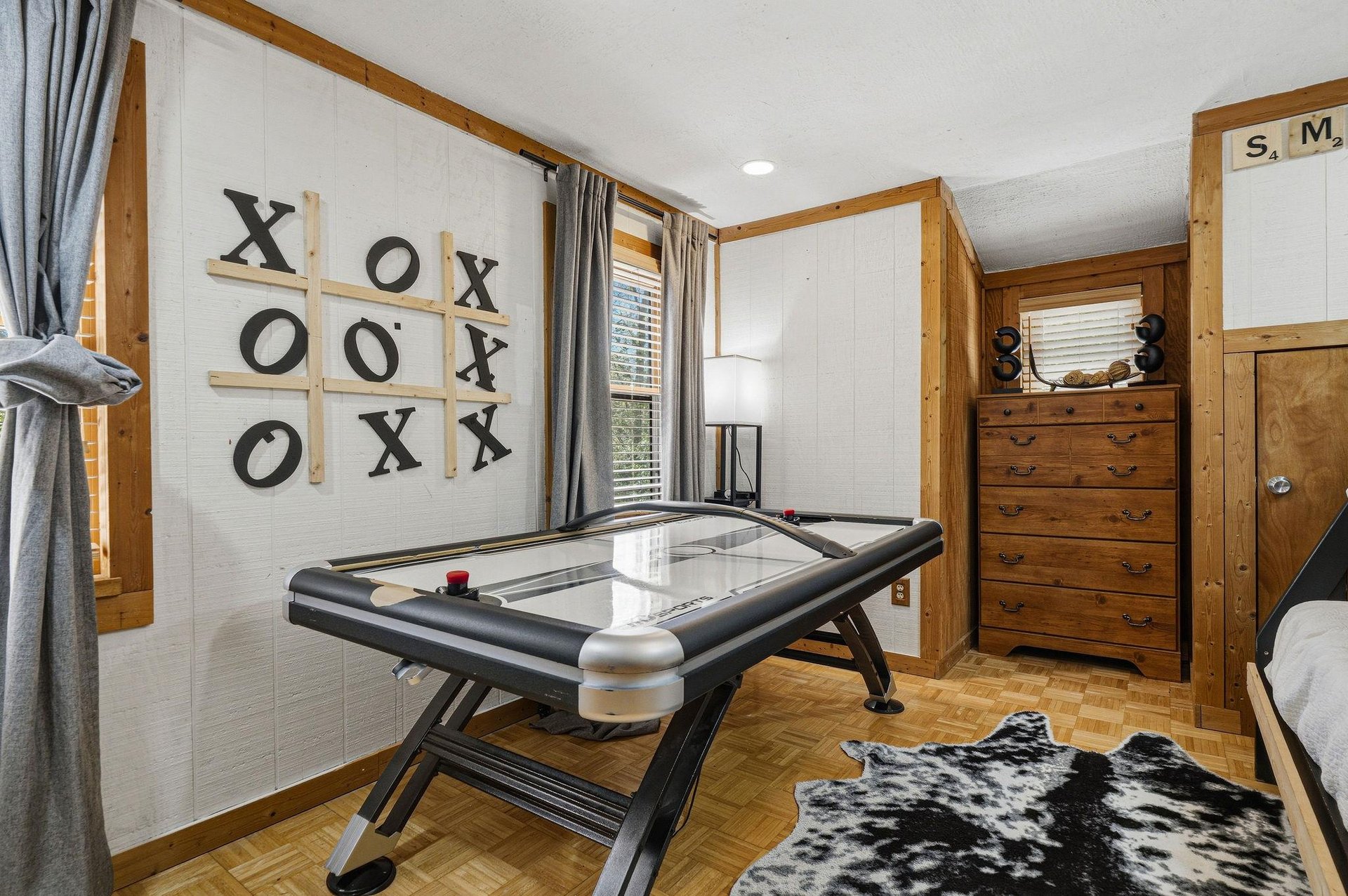 Challenge your family to friendly competition in this game room featuring air hockey and tictactoe fun.