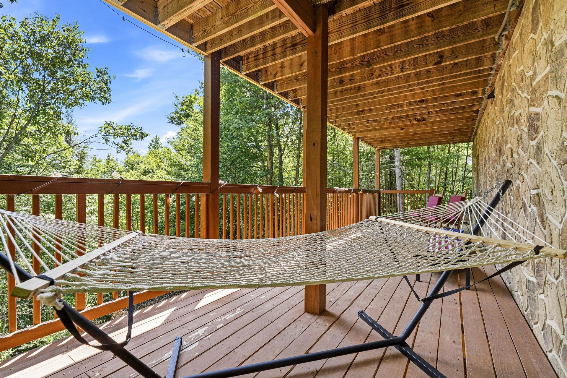 Settle into your hammock and let the forest breeze wash over you. This covered deck invites peaceful moments surrounded by lush trees and endless sky.