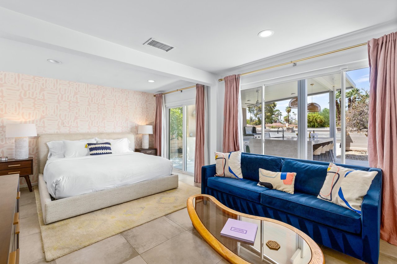 King size bed, seating area with double sofa bed, patio access, and ensuite bathroom.