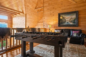 Your loft game room awaits with warm wood and a sturdy foosball table for friendly competition. Sink into the leather chair between rounds and enjoy the rustic charm of vaulted ceilings.