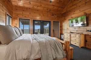 Sink into the plush bed surrounded by warm pine wood and wake up to stunning mountain views through your private balcony doors—perfect for peaceful mornings.
