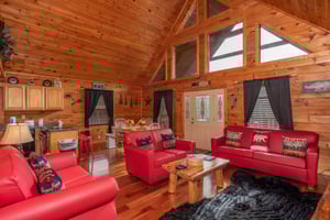 Living room with vaulted ceiling, looking into the dining room and kitchen at Hibernation Station, a 3bedroom cabin rental located in Pigeon Forge