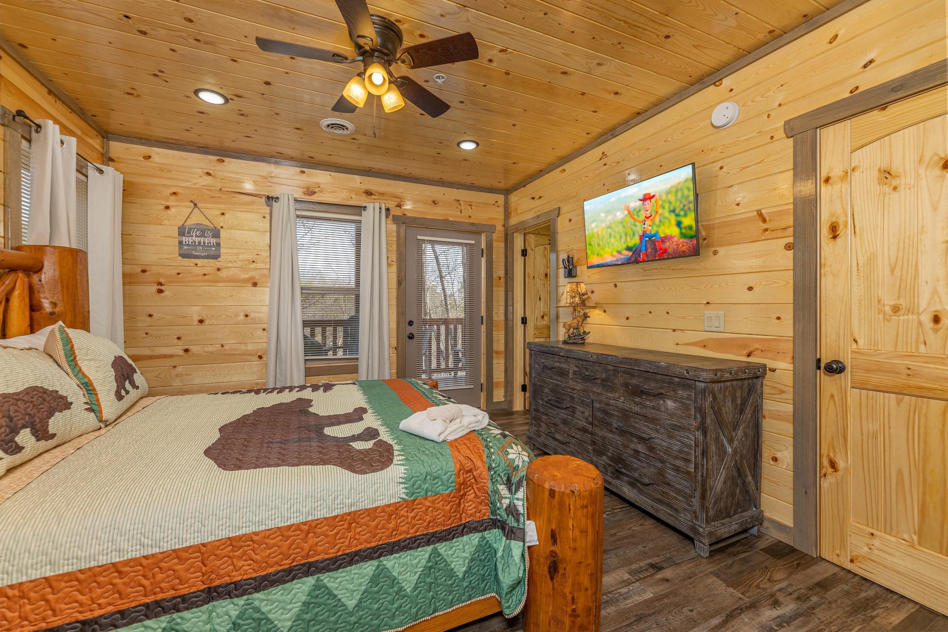 Dresser, second TV, and deck access in a bedroom at Everlys Splash, a 4 bedroom cabin rental located in Pigeon Forge