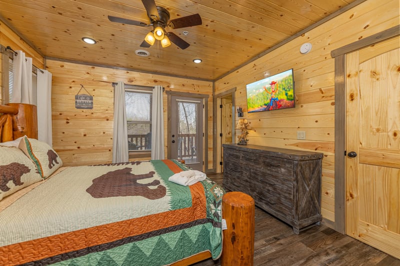 Dresser, second TV, and deck access in a bedroom at Everlys Splash, a 4 bedroom cabin rental located in Pigeon Forge