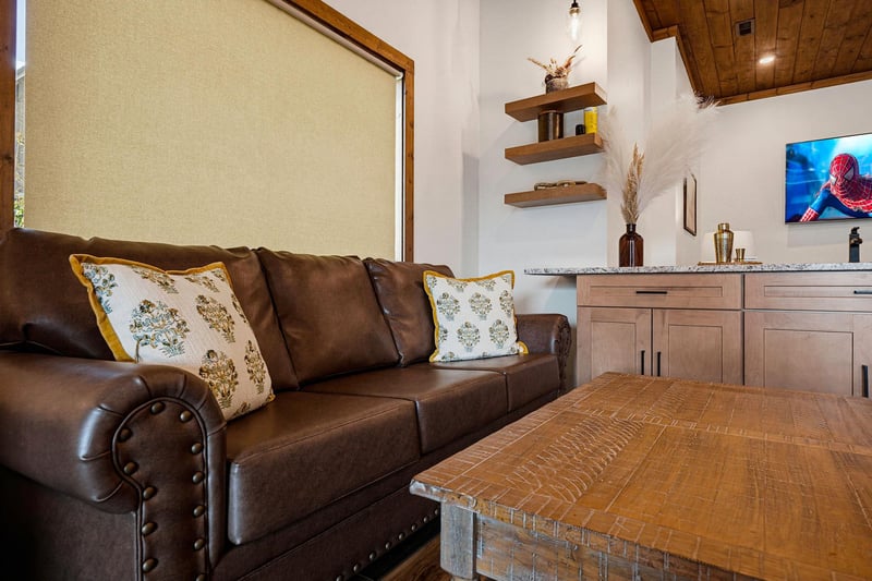 Settle in and unwind on the plush leather sofa, where warm wood tones and thoughtful details create your perfect home away from home.