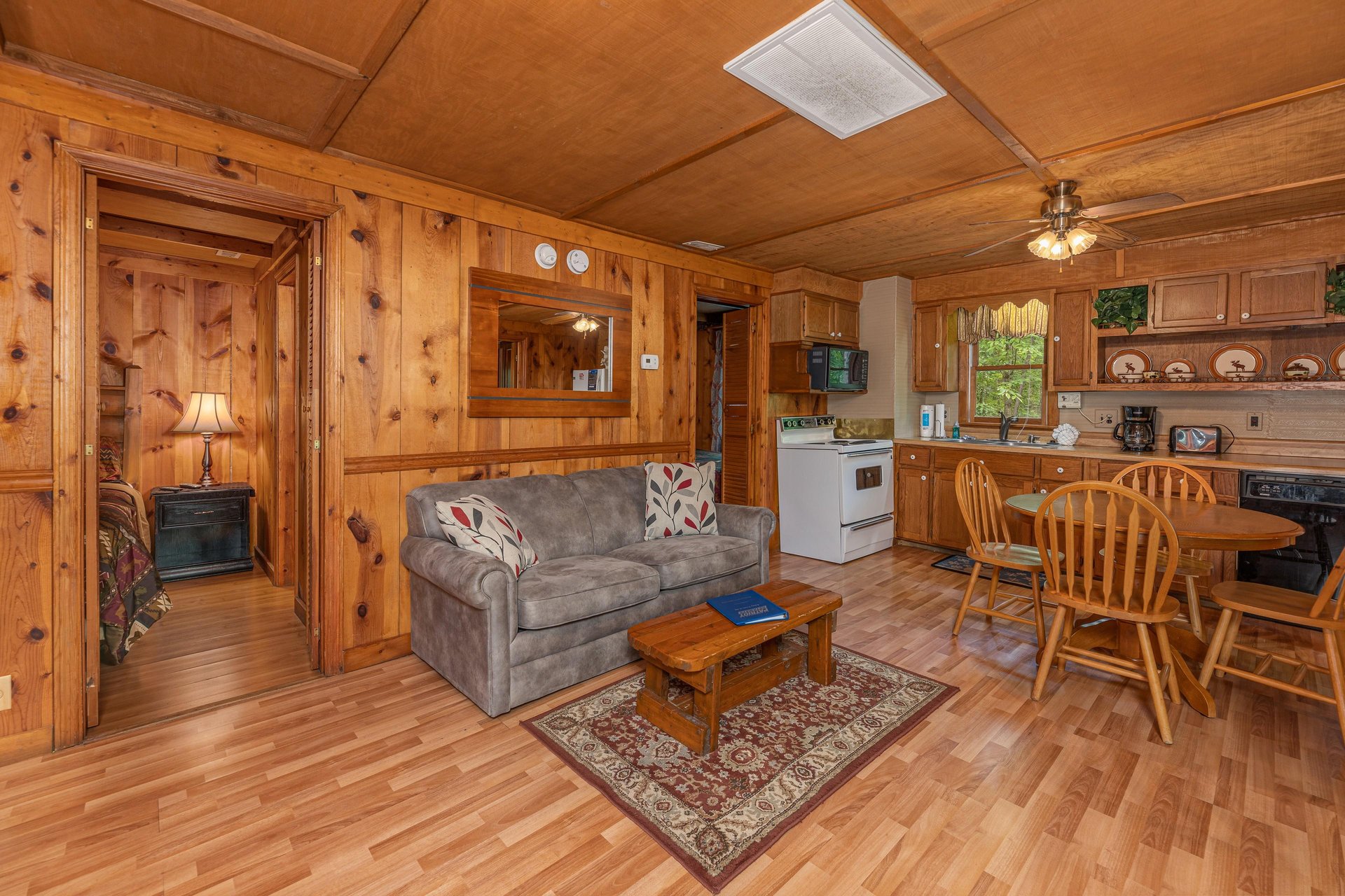 Living room with loveseat and dining table for four at Heavenly Hideaway, a 2bedroom cabin rental located in Gatlinburg