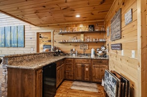 Your rustic kitchen features granite countertops, warm wood cabinetry, and a charming bar setup perfect for making memories with friends and family.