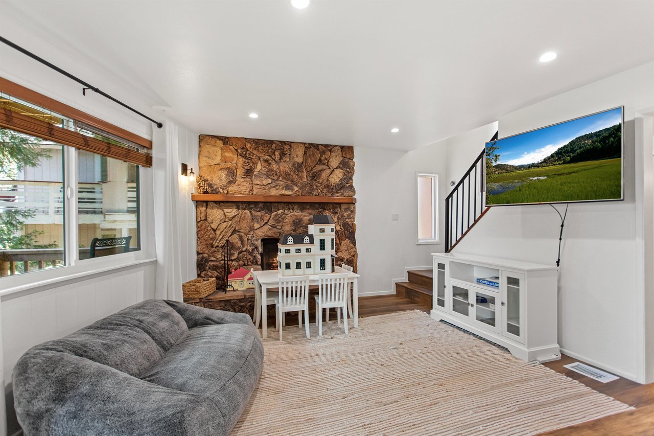 Downstairs living space with fireplace, TV, lower deck access, and near 3rd bedroom.