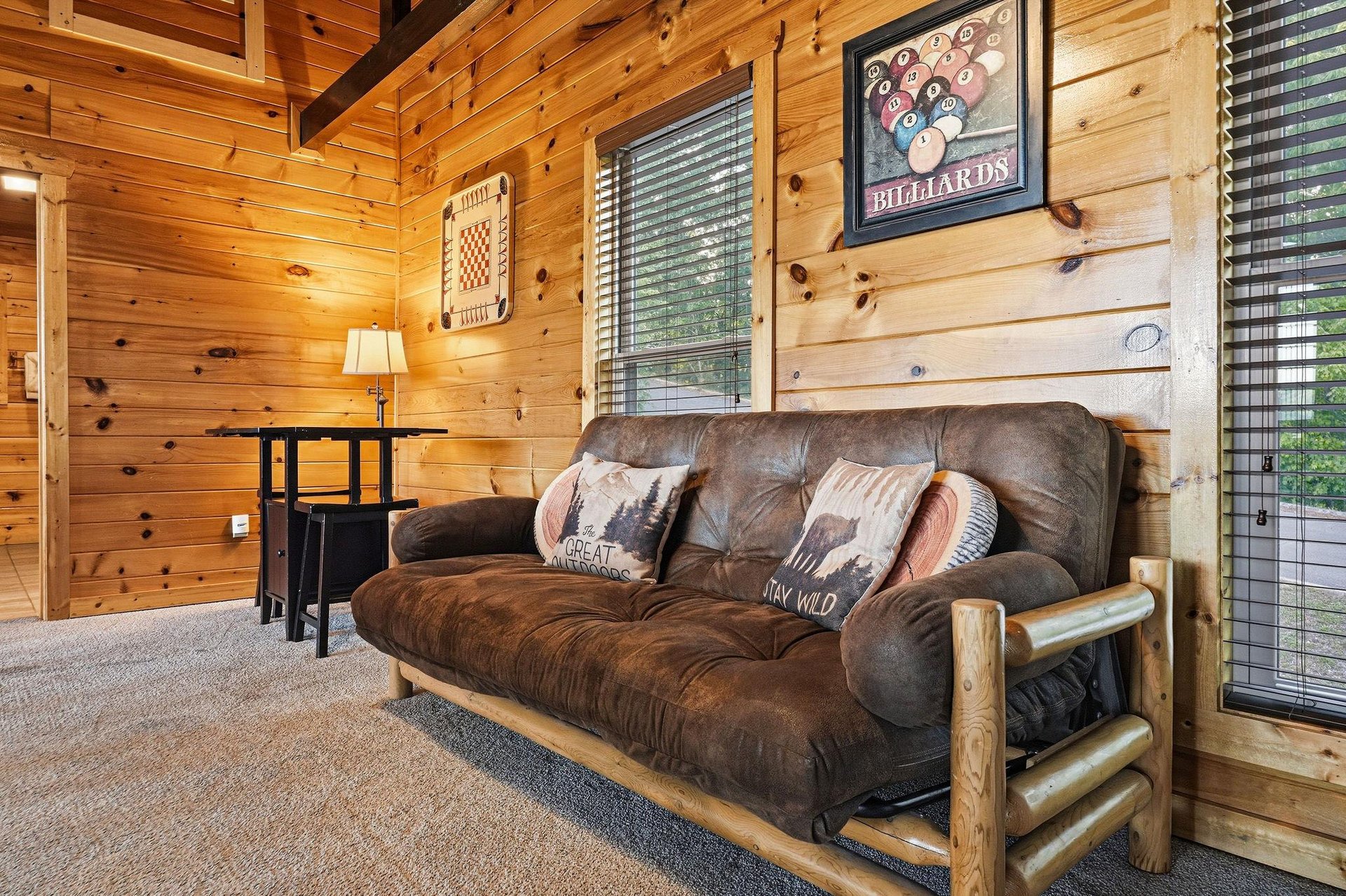 Unwind in this cozy cabin living room, where rustic wood walls and plush seating invite you to kick back and relax after a day of adventure.
